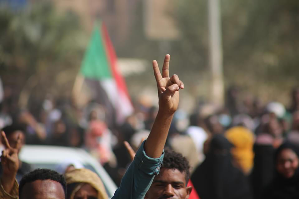 Pro-democracy protesters flash the victory sign as they take to the streets to condemn a takeover by military officials, in Khartoum, Sudan, Monday Oct. 25, 2021. Sudan’s military seized power Monday, dissolving the transitional government hours after troops arrested the acting prime minister and other officials. The takeover comes more than two years after protesters forced the ouster of longtime autocrat Omar al-Bashir and just weeks before the military was expected to hand the leadership of the council that runs the African country over to civilians. (AP Photo/Ashraf Idris)