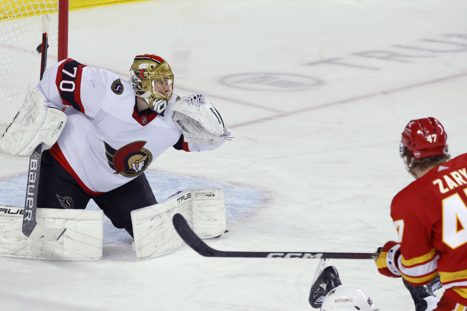 Calgary Flames' Connor Zary, right, scores on Ottawa Senators goalie Joonas Korpisalo during the first period of an NHL hockey game Tuesday, Jan. 9, 2024, in Calgary, Alberta. (Larry MacDougal/The Canadian Press via AP)