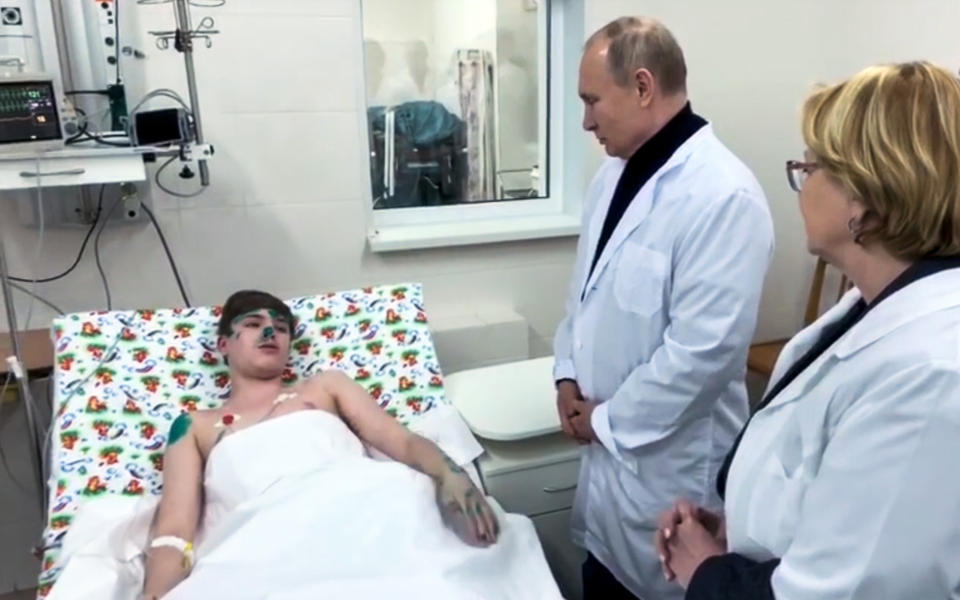 In this video grab provided by RU-RTR Russian television, Russian President Vladimir Putin, second right, speaks to a boy wounded during collapsing of the apartment building in Magnitogorsk, a city of 400,000 people, about 1,400 kilometers (870 miles) southeast of Moscow, Russia, Monday, Dec. 31, 2018. At least four people died Monday when part of a 10-story apartment building collapsed in Russia's Ural Mountains region, and hundreds of rescuers searched for survivors under the rubble in the frigid weather. (RU-RTR Russian Television via AP)