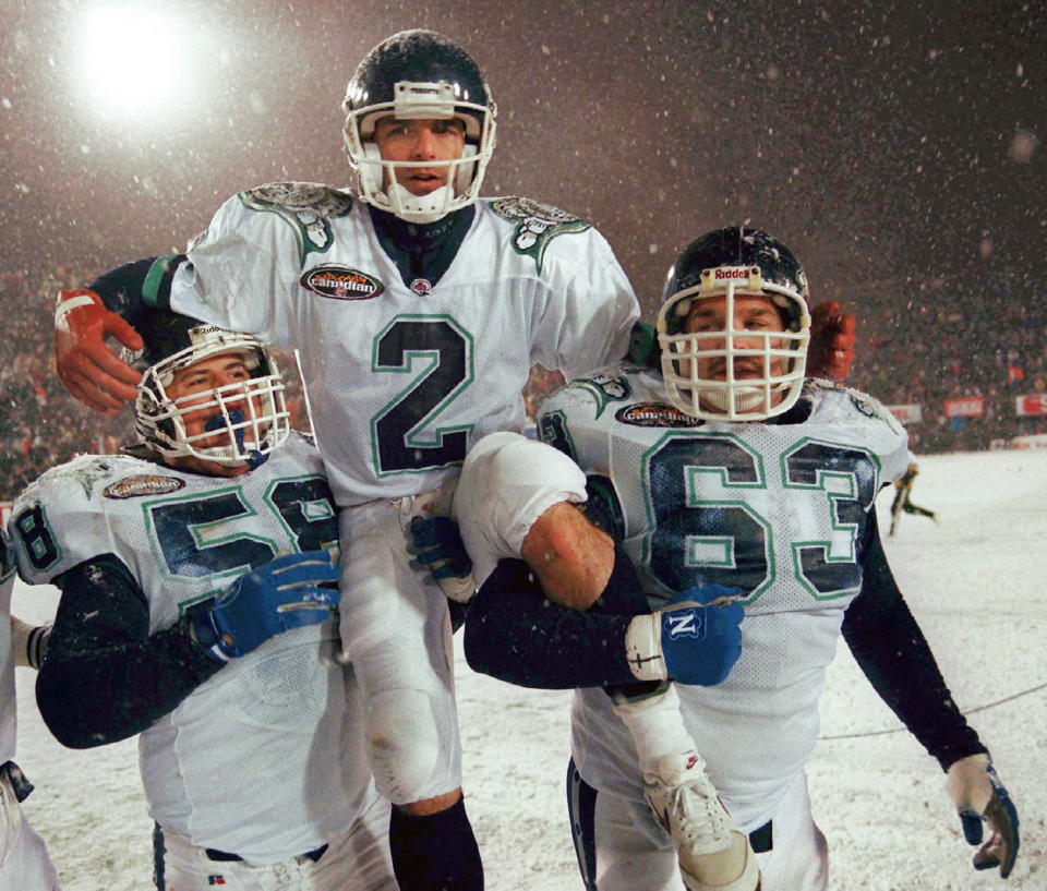 Toronto Argonauts quarterback Doug Flutie is carried on the shoulders of teammates Chris Gioskos, left, and Mike Kiselak after their 43-37 Grey Cup win over the Edmonton Eskimos in Hamilton in 1996. (The Canadian Press)