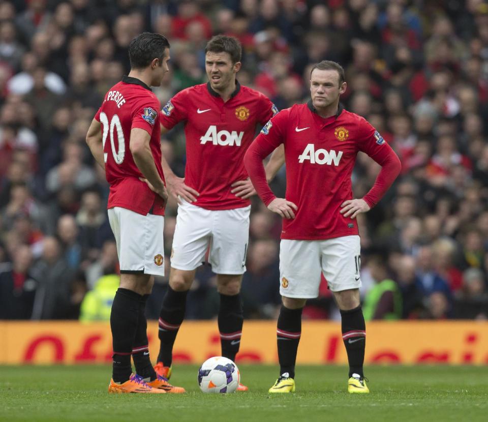 Manchester United's Wayne Rooney, right, Michael Carrick, centre, and Robin van Persie wait for play to restart after Liverpool's first goal during their English Premier League soccer match at Old Trafford Stadium, Manchester, England, Sunday March 16, 2014. Liverpool won the game 3-0. (AP Photo/Jon Super)