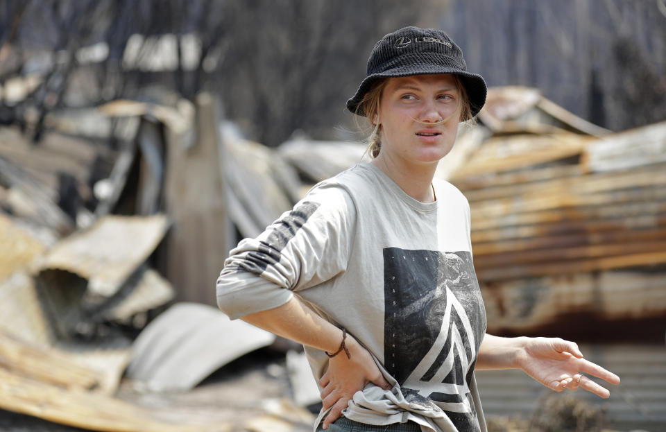 Skye Threlfall talks about how she and her brother and sister saved their house a New Year's Eve wildfire at Nerrigundah, Australia, Monday, Jan. 13, 2020. The tiny village of Nerrigundah in New South Wales has been among the hardest hit by Australia's devastating wildfires, with about two thirds of the homes destroyed and a 71-year-old man killed. (AP Photo/Rick Rycroft)