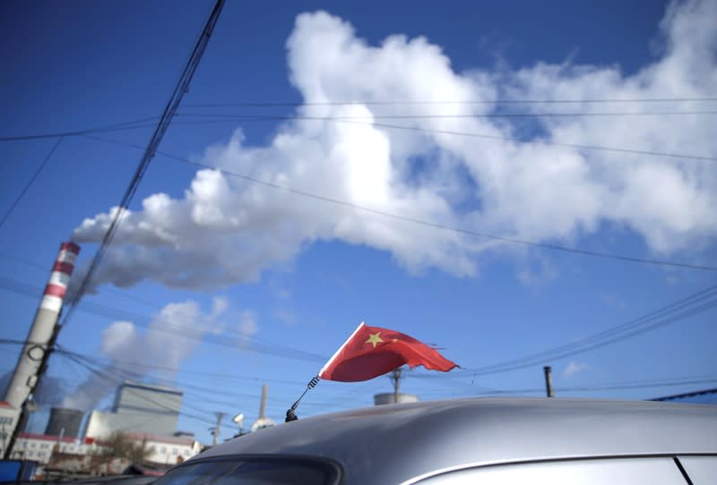 A Chinese flag is seen on the top of a car near a coal-fired power plant in Harbin