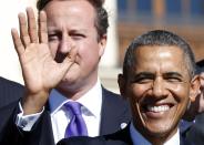 U.S. President Barack Obama waves as he stands in front of British Prime Minister David Cameron during a group photo at the G20 Summit in St. Petersburg September 6, 2013. REUTERS/Kevin Lamarque (RUSSIA - Tags: BUSINESS POLITICS)