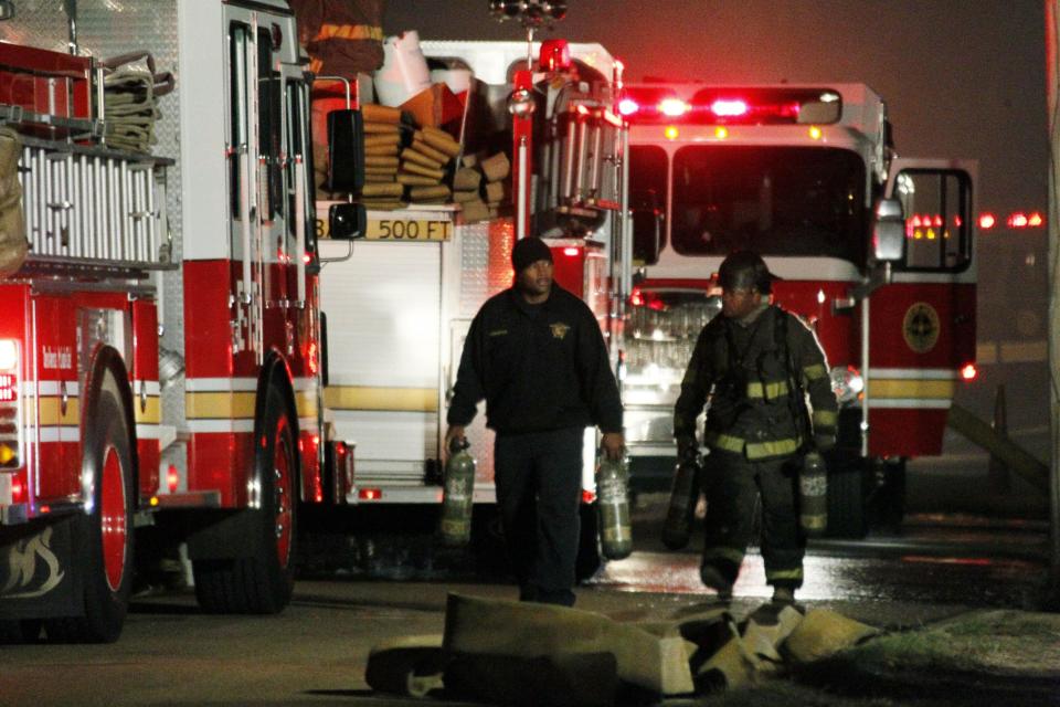 Fire fighters begin to clean up site at a west Jackson, Miss., home where authorities say a small plane carrying three people crashed shortly after 5 p.m. Tuesday evening, Nov. 13, 2012. The home's resident is believed to have escaped but authorities have not released names of plane's passengers. (AP Photo/Rogelio V. Solis)