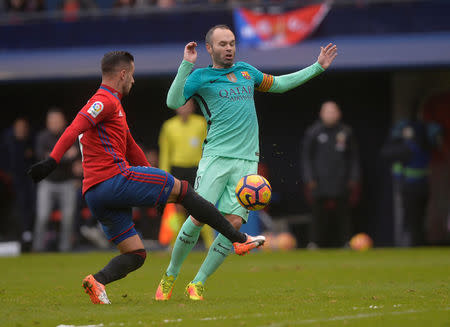 Football Soccer - Osasuna v Barcelona - Spanish La Liga Santander - El Sadar, Pamplona, Spain - 10/12/2016 Barcelona's Andres Iniesta fights for the ball with Osasuna's Sergio Leon. REUTERS/Vincent West