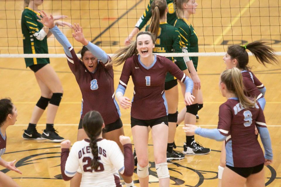 Okemos' Taylor Stephens (8) and Kayla Ozanich (1) celebrate after winning the first game in a 3-0 victory over Howell in a district championship match at Brighton Thursday, Nov. 3, 2022.