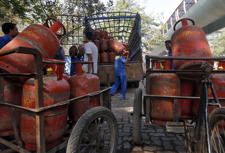 Workers load liquefied petroleum gas (LPG) cooking cylinders onto a supply truck outside a distribution centre in Mumbai February 19, 2015. REUTERS/Shailesh Andrade