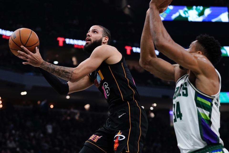 Miami Heat's Caleb Martin shoots past Milwaukee Bucks' Giannis Antetokounmpo during the first half of an NBA basketball game Wednesday, March 2, 2022, in Milwaukee . (AP Photo/Morry Gash)