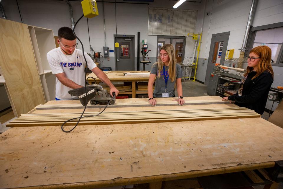 Tyler Hicks Hannah Deese and Paige Hancock sand wood strips for a cabinet as students work on construction type assignments in a Cabinet Making/Construction class in the ACE Academy at Bartow High School In Bartow  Fl. Wednesday August 31,2022.The Bartow High School Academy trains students to fill construction jobs amid worker shortage. Labor Day feature on construction worker shortage and efforts to add skilled workers.Ernst Peters/The Ledger