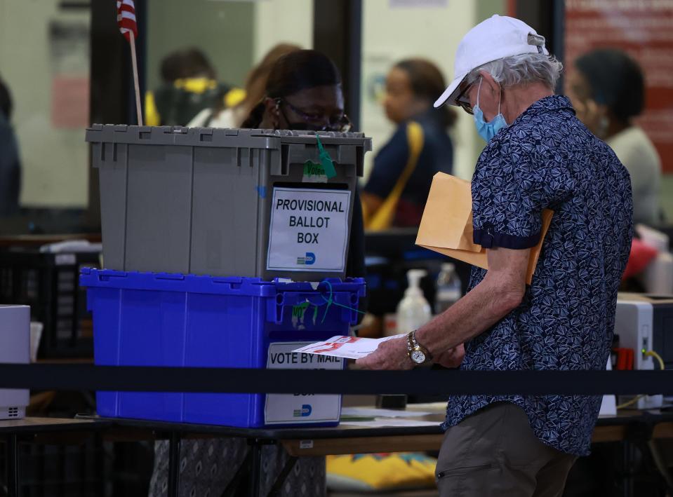 A voter drops a ballot into the "vote by mail" slot at the Stephen P. Clark Government Center polling station Wednesday in Miami, Florida. Early voting opened this week across Florida for the Nov. 8 midterm elections.