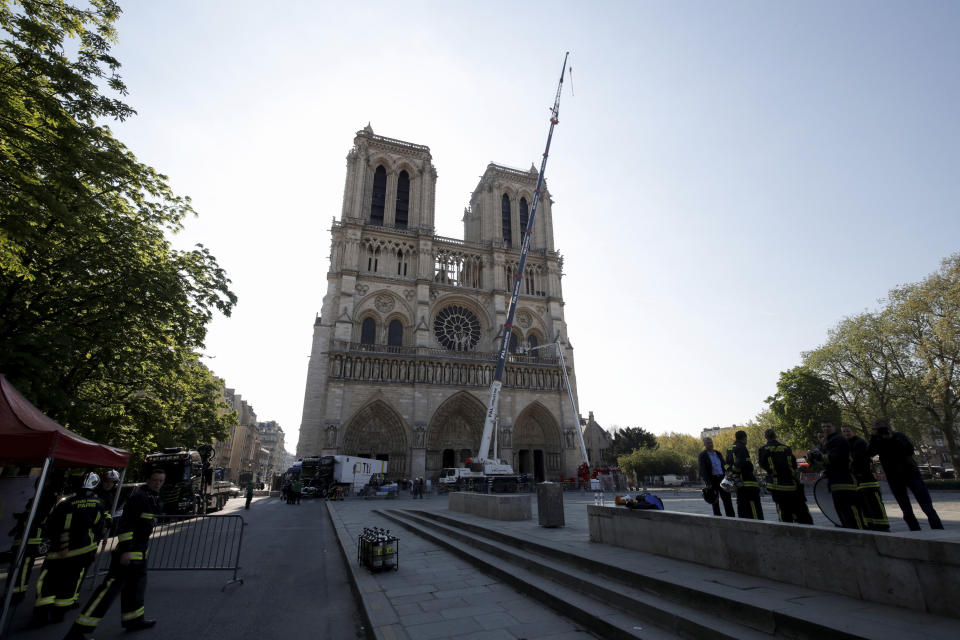 A crane works at Notre-Dame cathedral in Paris, Friday, April 19, 2019. Rebuilding Notre Dame, the 800-year-old Paris cathedral devastated by fire this week, will cost billions of dollars as architects, historians and artisans work to preserve the medieval landmark. (Philippe Wojazer/Pool via AP)