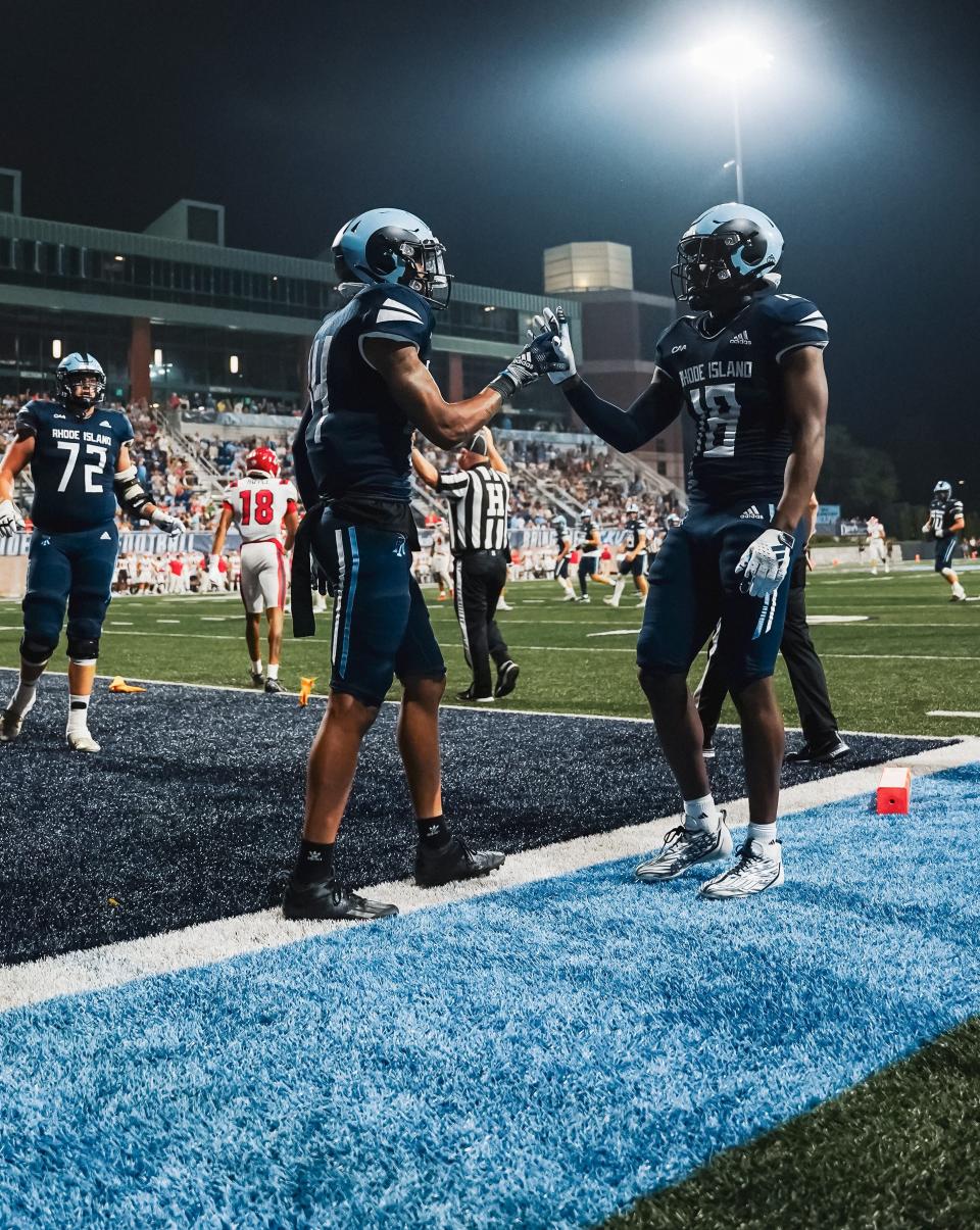 Rhode Island's Marquis Buchanan, left, and Kahtero Summers react after a touchdown Friday night against Stony Brook. It was URI's first Friday night game in Meade Stadium history. 9/9/23