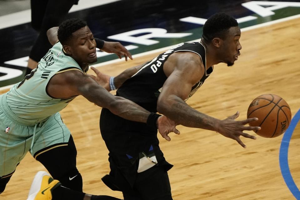 Milwaukee Bucks' Thanasis Antetokounmpo drives past Charlotte Hornets' Terry Rozier during the first half of an NBA basketball game Friday, April 9, 2021, in Milwaukee. (AP Photo/Morry Gash)