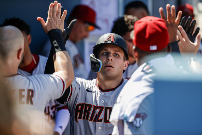Arizona Diamondbacks' Daulton Varsho (12) is congratulated in the dugout after hitting a solo home run during the third inning of a baseball game against the Los Angeles Dodgers, Tuesday, Sept 20, 2022, in Los Angeles. (AP Photo/Ringo H.W. Chiu)