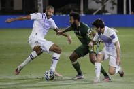 Orlando City forward Dom Dwyer (14), left, and midfielder Mauricio Pereyra (10) attempt to control the ball as Portland Timbers midfielder Eryk Williamson (30) defends, during the first half of an MLS soccer match, Tuesday, Aug. 11, 2020, in Kissimmee, Fla. (AP Photo/John Raoux)