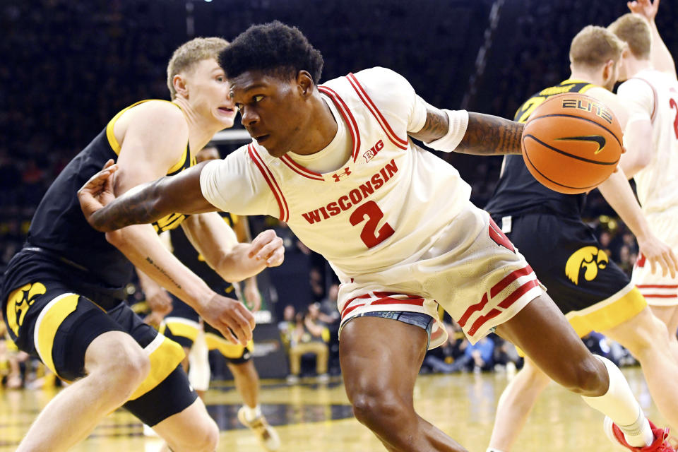 Wisconsin guard AJ Storr (2) drives to the basket past Iowa guard Josh Dix (4) during the first half of an NCAA college basketball game, Saturday, Feb. 17, 2024, in Iowa City, Iowa. (AP Photo/Cliff Jette)