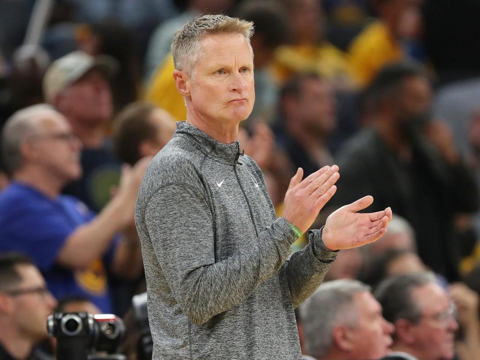 Steve Kerr frowns and claps his hands during a Warriors game.
