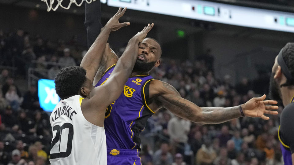 Los Angeles Lakers forward LeBron James, right, is fouled by Utah Jazz center Udoka Azubuike (20) during the first half of an NBA basketball game Tuesday, April 4, 2023, in Salt Lake City. (AP Photo/Rick Bowmer)