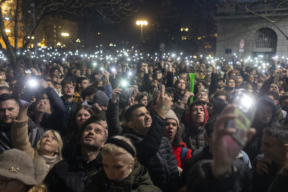 Serbian opposition supporters hold lights during a protest attended by several thousand people, outside the country's electoral commission in Belgrade, Serbia, Monday, Dec. 18, 2023. An early official vote count of Serbia's weekend election on Monday confirmed victory for the ruling populist party in a parliamentary vote in the Balkan country, but political tensions rose over reported irregularities in the capital, Belgrade. (AP Photo/Marko Drobnjakovic)