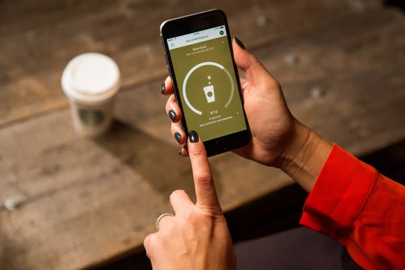 A woman using Starbucks' app on her mobile phone.