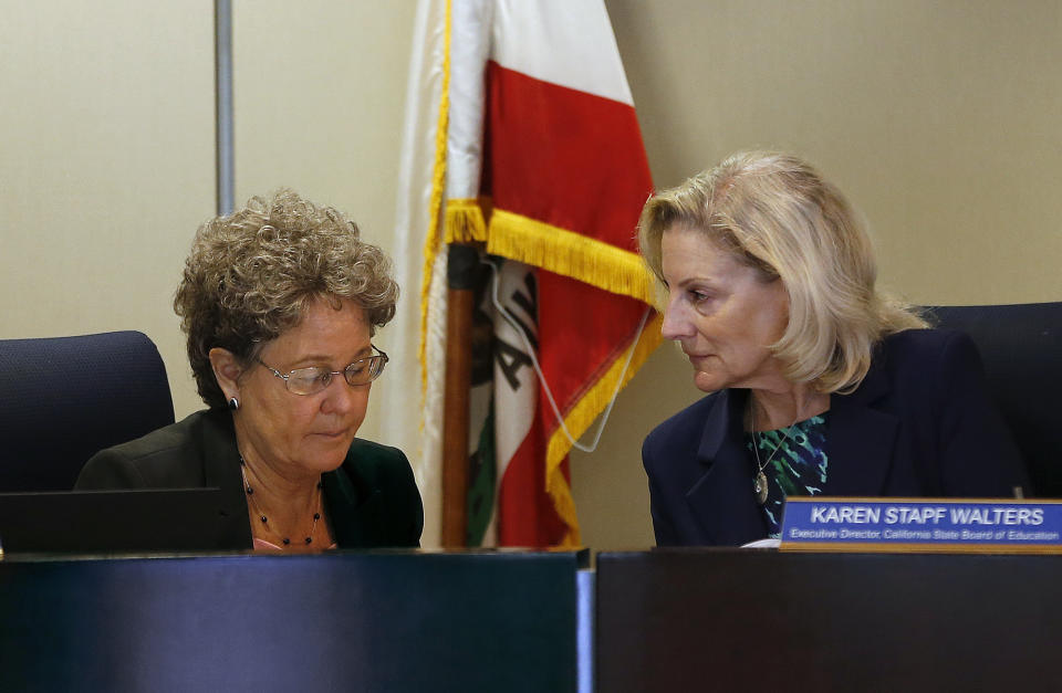 Linda Darling-Hammond, left, president of the State Board of Education huddles with the Karen Stapf Walters, right, the boards executive director, during a meeting where proposed changes to sex education guidance for teachers are to be voted on Wednesday, May 8, 2019, in Sacramento, Calif. The guidance is not mandatory but it gives teachers ideas about how to teach a wide range of health topic including speaking to children about gender identity. (AP Photo/Rich Pedroncelli)