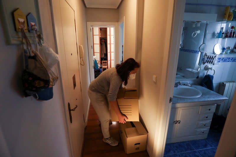 Ines Alcolea arranges moving boxes before leaving her rented apartment in Madrid
