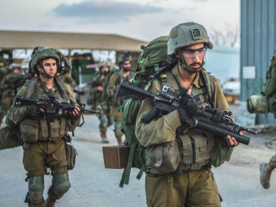 Soldiers marching with automatic weapons