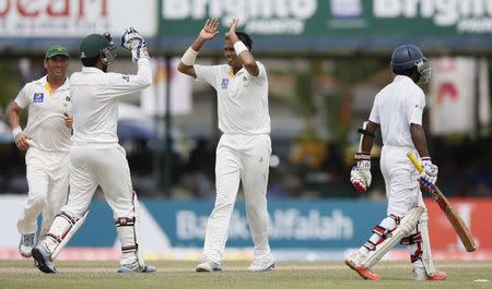 Pakistan's Zulfiqar Babar (2nd R) celebrates with his teammates Sarfraz Ahmed (2nd L) and Yasir Shah after taking the wicket of Sri Lanka's Kaushal Silva (R) during the second day of their second test cricket match against Pakistan in Colombo June 26, 2015. REUTERS/Dinuka Liyanawatte