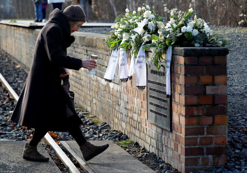 A woman places a candle at the Gleis 17 (Platform 17) memorial at Berlin-Grunewald train station in Berlin