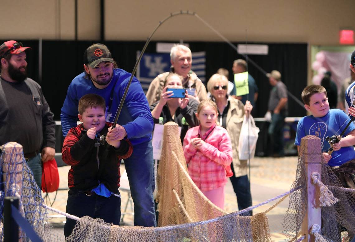 Kash Daniel and C. D. Howard, 6, of Carlisle hooked a fish on the simulator at the 2019 Kentucky Sport Boat and Recreation Show.