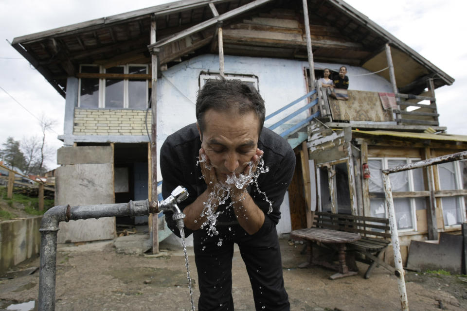 The unexpected movie star, Nazif Mujic, washes his face in front of his home in the village of Poljice,150 kms northeast of Sarajevo, on Wednesday, April 10, 2013. People in the Gypsy village of Poljice say they will never forget the night they almost fell off their chairs two months ago. Did they really hear the elegant woman on TV correctly? Could she really be talking about their neighbor, the toothless man who passed his days selling scrap metal and lived in the shack down the road? The camera switched to a frightened-looking Najif Mujic. Yes it was him. THEIR Nazif _ who had just left Matt Damon and Jude Law in the dust to win the best actor award at the Berlin Film Festival. (AP Photo/Amel Emric)