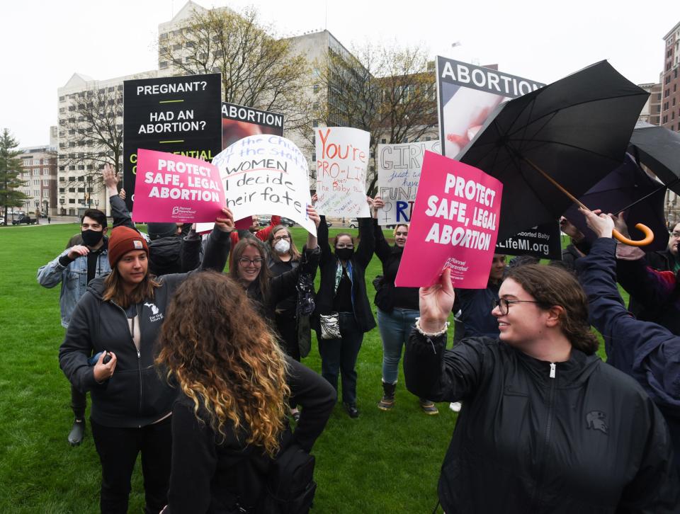 Abortion-rights advocates try to block anti-abortion signage during a rally at the state Capitol in Lansing, Mich., Tuesday, May 2, 2022. [AP Photo/Matthew Dae Smith via Lansing State Journal]