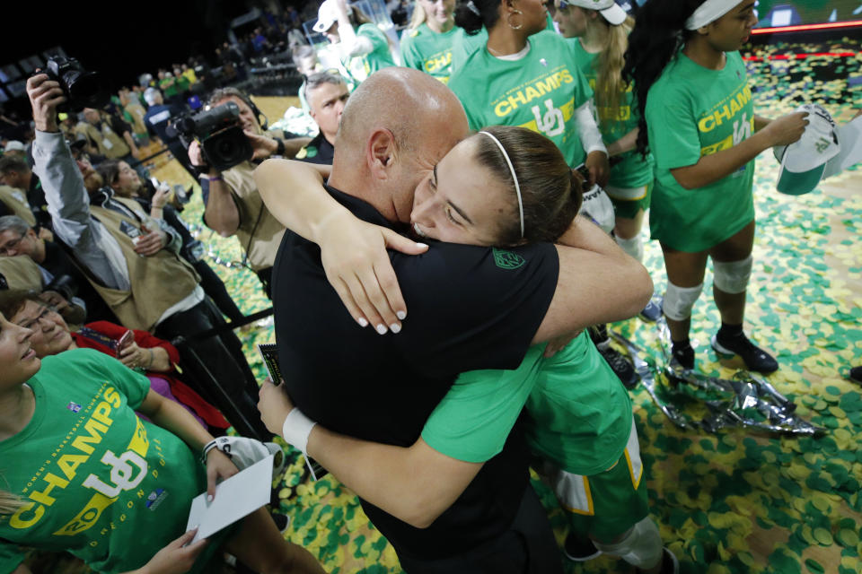 Oregon's Sabrina Ionescu, right, embraces head coach Kelly Graves after defeating Stanford in an NCAA college basketball game in the final of the Pac-12 women's tournament Sunday, March 8, 2020, in Las Vegas. (AP Photo/John Locher)