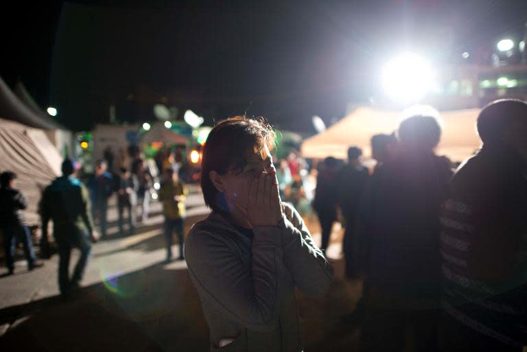 A relative of the missing passengers from the sunken ferry waits for news at the harbour in Jindo early on April 17, 2014