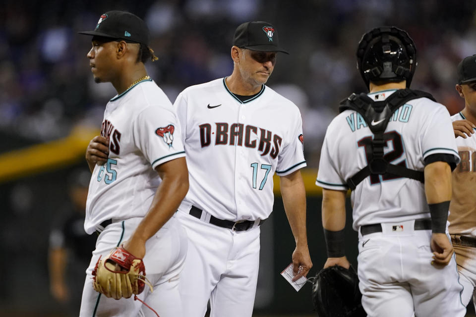 Arizona Diamondbacks manager Torey Lovullo (17) pulls pitcher Luis Frias (65) from the game during the seventh inning of a baseball game against the Los Angeles Dodgers, Thursday, May 26, 2022, in Phoenix. (AP Photo/Matt York)