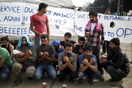 Migrants and refugees with their mouths taped stage a protest at a makeshift camp at the Greek-Macedonian border near the village of Idomeni, Greece, April 1, 2016. REUTERS/Marko Djurica