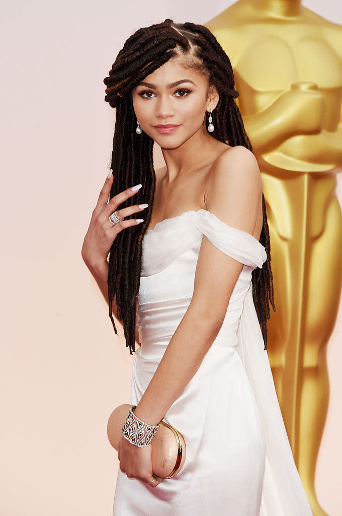 Zendaya with long braids in a gown at an event