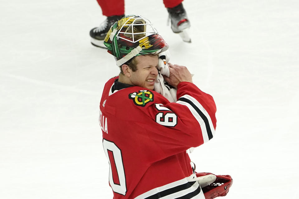 Chicago Blackhawks goaltender Collin Delia wipes his face during a break in the action in the second period of an NHL hockey game against the Dallas Stars Monday, May 10, 2021, in Chicago. (AP Photo/Charles Rex Arbogast)