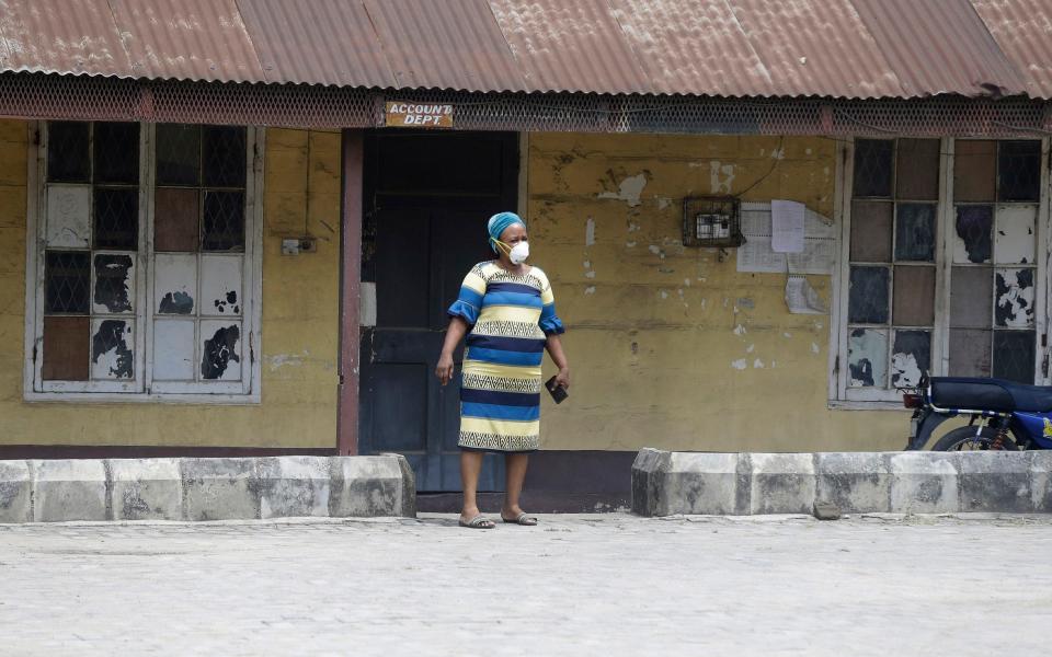 A woman wearing a face mask walks at the Yaba Mainland hospital where the first Nigerian victims of the COVID-19 virus are being treated in Lagos Nigeria - Sunday Alamba / AP