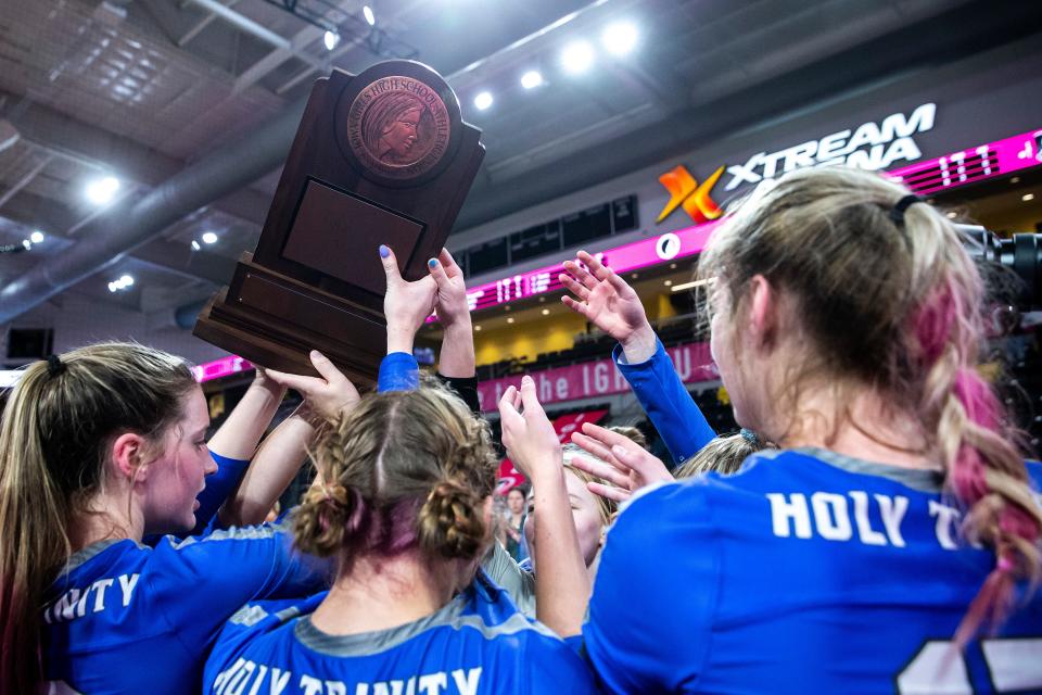 Holy Trinity players hold up their trophy after a Class 1A state volleyball quarterfinal match against Gladbrook-Reinbeck, Tuesday, Nov. 1, 2022, at Xtream Arena in Coralville, Iowa.