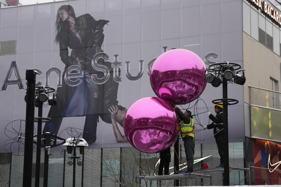 Workers install decorations ahead of the Christmas festival at a mall in Beijing, Thursday, Dec. 14, 2023. China's economy will slow next year, with annual growth falling to 4.5% from 5.2% this year despite a recent recovery spurred by investments in factories and construction and in demand for services, The World Bank said in a report issued Thursday. (AP Photo/Ng Han Guan)