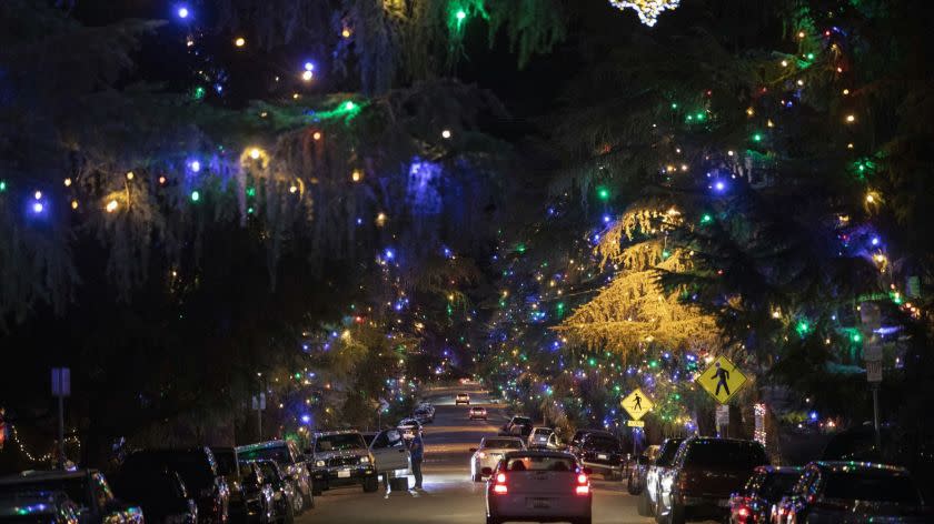 LOS ANGELES - DECEMBER 9, 2018: Motorists cruise Santa Rosa Avenue, better known as Christmas Tree Lane, in Altadena, California to view the 0.7 mile of deodar cedar trees that have been lit by community volunteers annually since 1920. In 1990, the lane was designated as California Historical Landmark No. 990. (Calvin B. Alagot / Los Angeles Times)