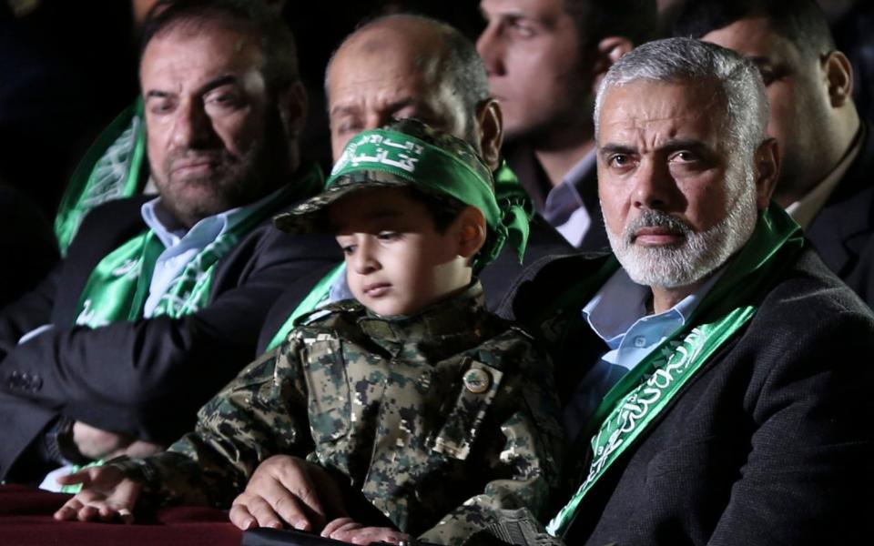 Hamas senior leader Sheikh Ismaeil Haneiya (R) seated with the son of Mazen Faqaa, senior leader of Ezz-Al Din Al Qassam Brigades, the armed wing of the Palestinian Hamas movement, at a memorial service in Gaza City - Credit:  EPA/MOHAMMED SABER