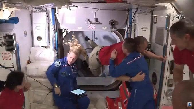 Expedition 64 commander Sergey Ryzhikov hugs Crew Dragon astronaut Soichi Noguchi while Mike Hopkins (right), Kate Rubins (left in blue jumpsuit) and Shannon Walker (far left) look on. / Credit: NASA