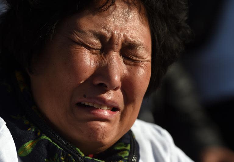 A family member of a passenger on missing on Malaysia Airlines flight MH370 cries during a protest near the Malaysian embassy in Beijing on March 8, 2015