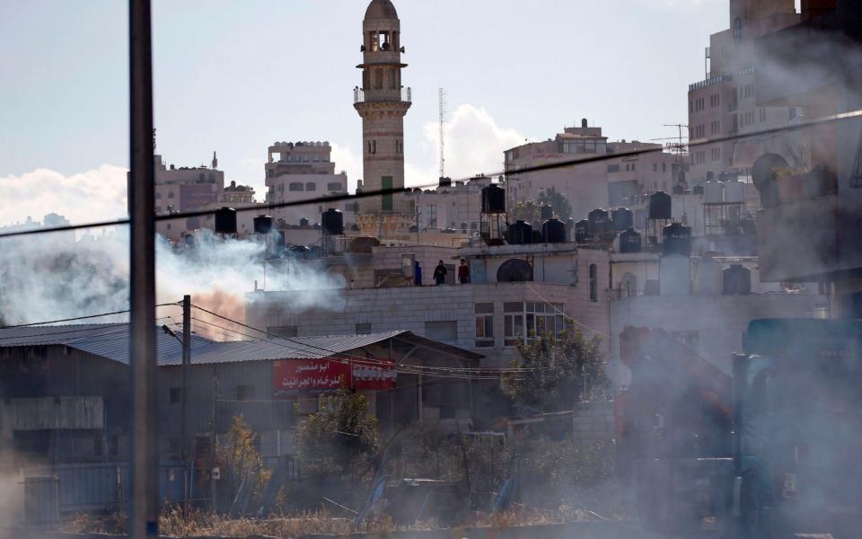 Smoke from burning tyres and tear gas billows during clashes between Palestinian demonstrators and Israeli soldiers in Ramallah, near the Jewish settlement of Beit El, in the occupied West Bank - AFP