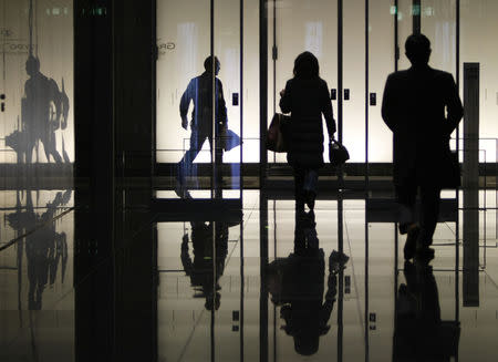 Pedestrians walk through an office building in Tokyo January 8, 2009. REUTERS/Yuriko Nakao/Files