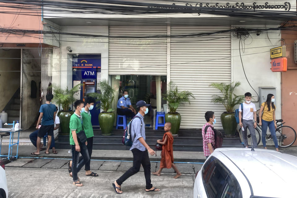 People walk past a bank and an ATM machine in Yangon, Myanmar on Nov. 12, 2021. The military takeover in Myanmar has set its economy back years, if not decades, as political unrest and violence disrupt banking, trade and livelihoods and millions slide deeper into poverty. (AP Photo)