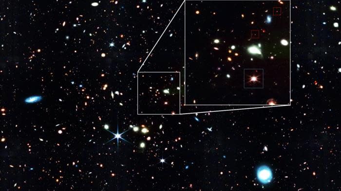 An image of a starry section of space; some little red sparkles are pointed out.